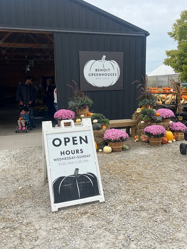 An Open sign in front of a greenhouse.